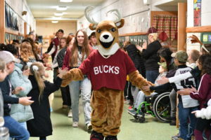 Bucky high fiving elementary students