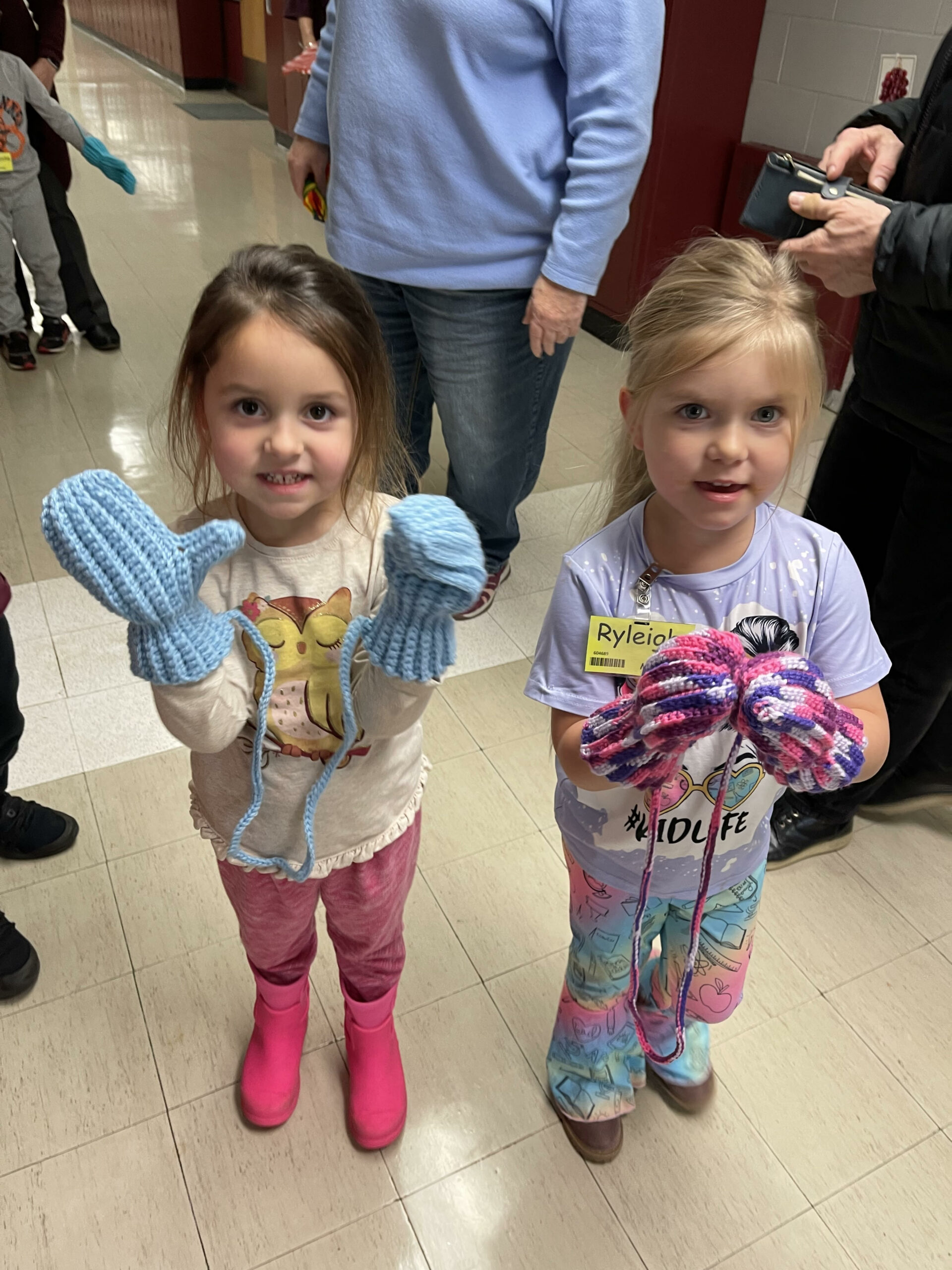 Pictures of preschool students receiving handmade mittens from the senior center