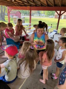 Picture of teacher painting students faces at field day