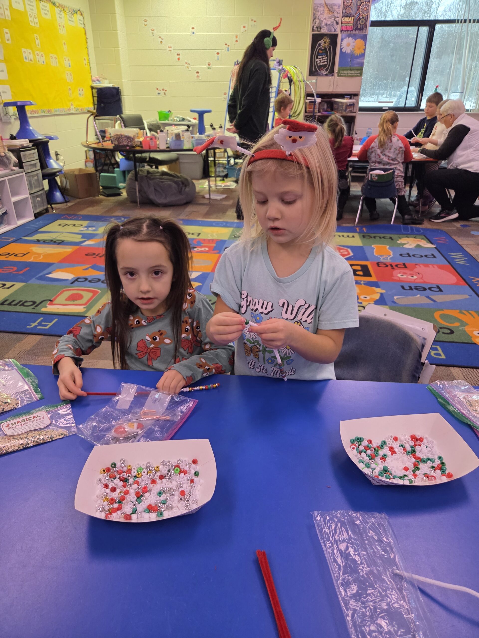 Two girls doing a bead craft.