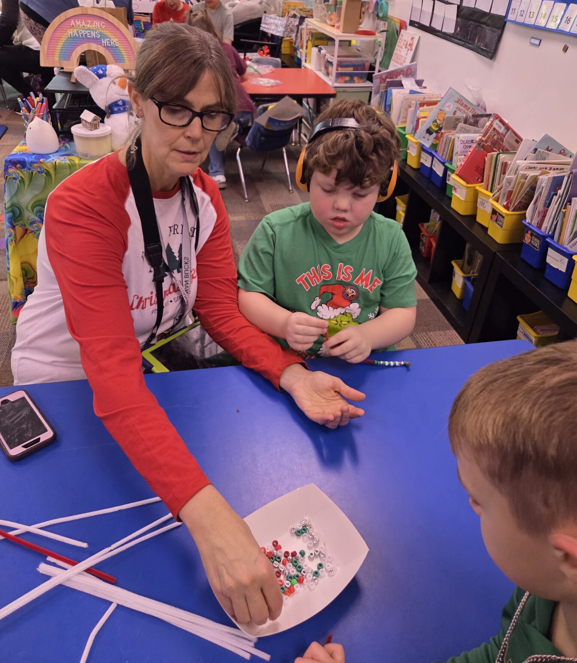 Mrs. VanDyke doing a bead craft with a student.