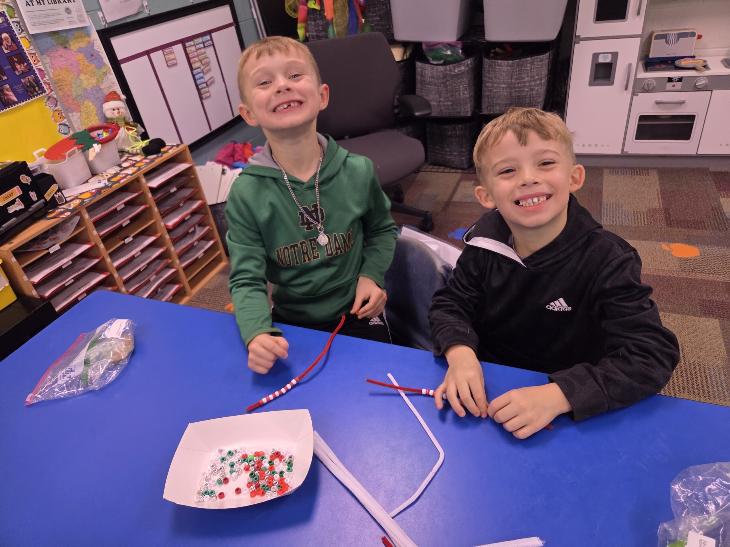 Two boys doing a bead craft.