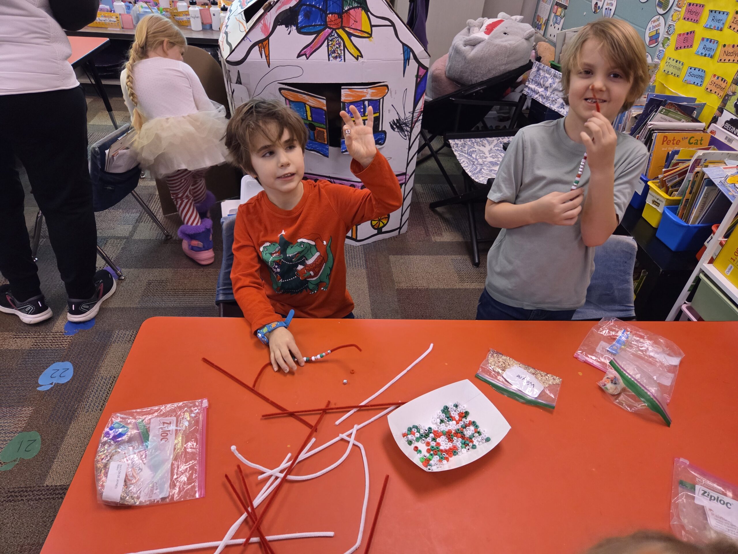 Two boys doing a bead craft.