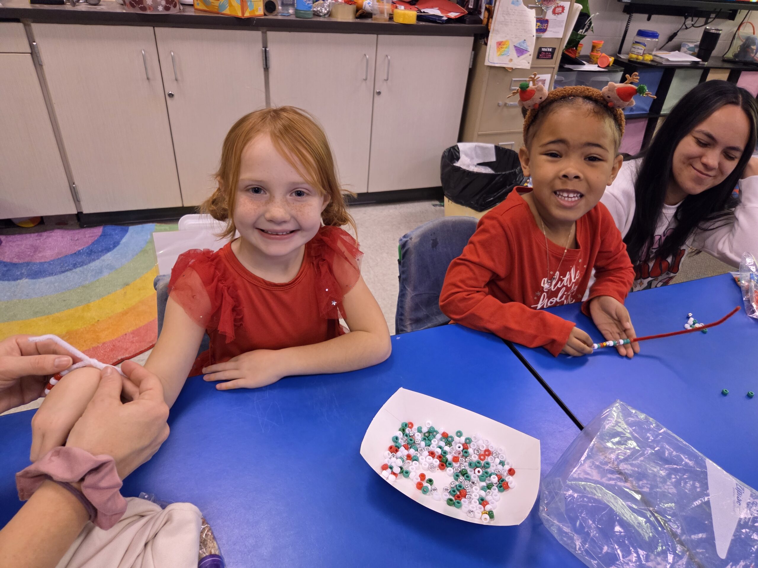 Two girls doing a bead activity.