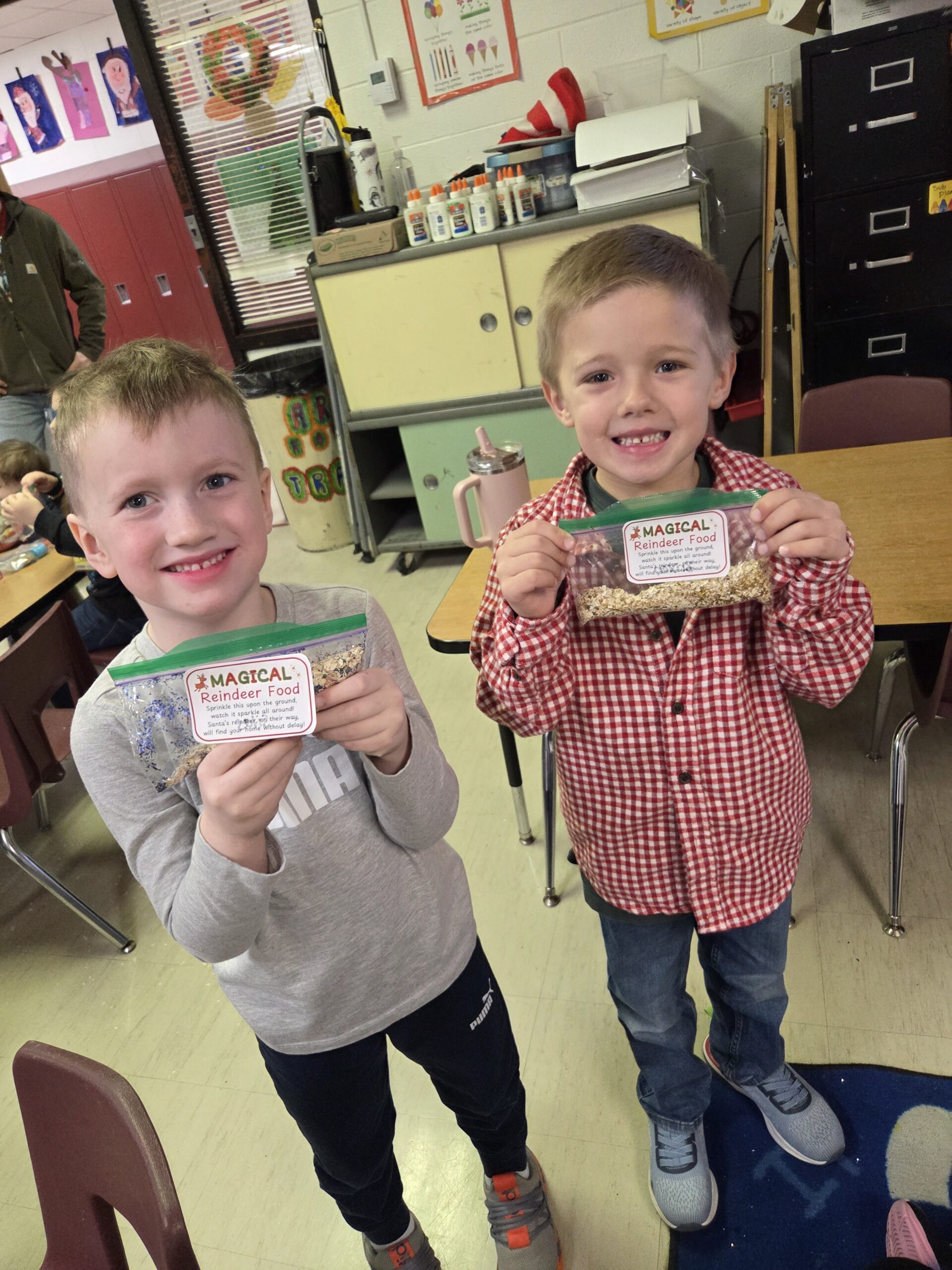 Two boys holding small bags of reindeer food.