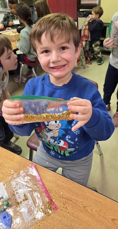 A boy holding a bag of reindeer food.