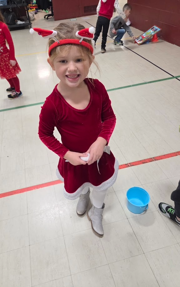 A girl playing a snowball game in the gym during jingle bell bash.